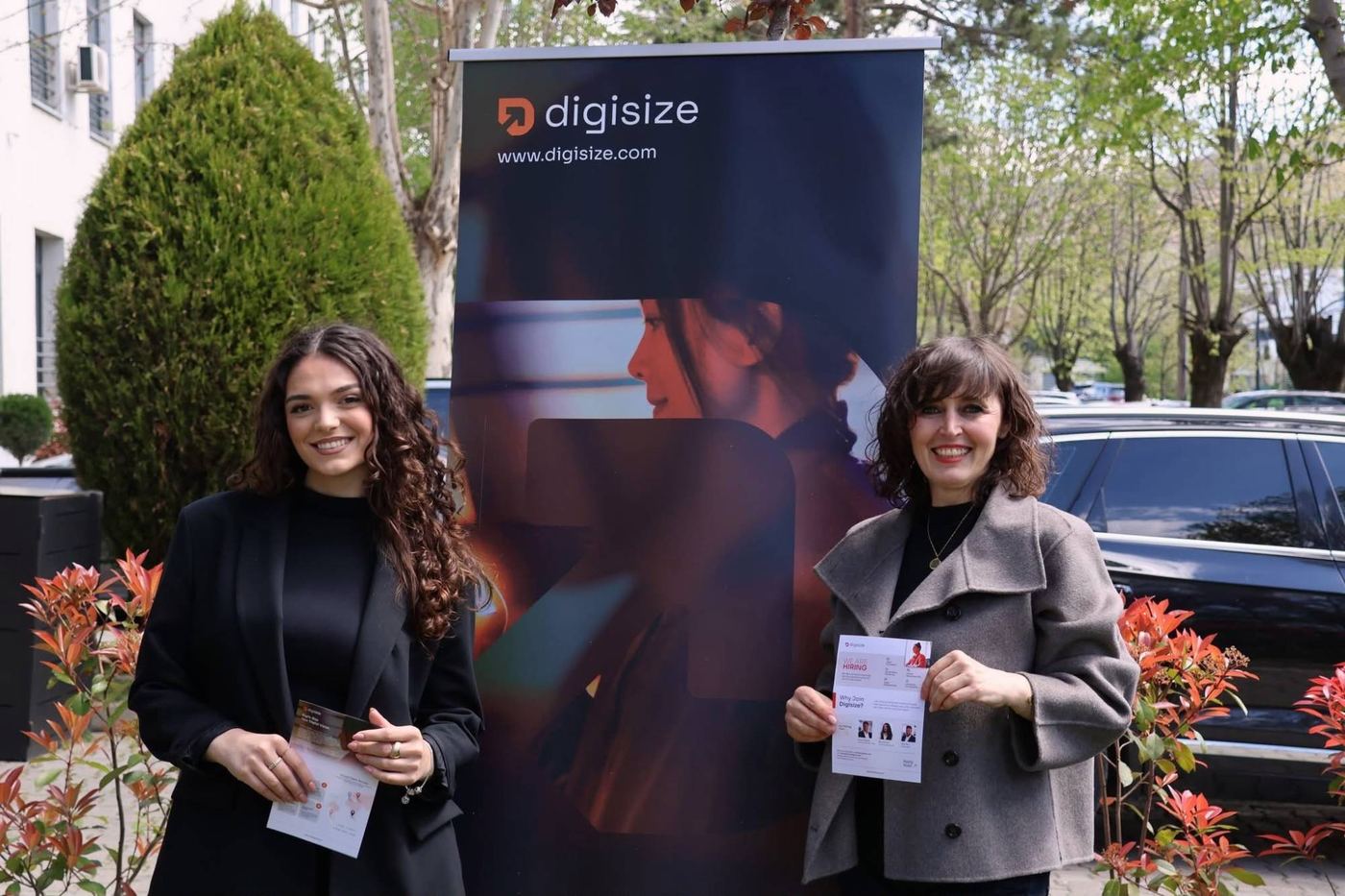 Two Digisize team members beside a Digisize banner