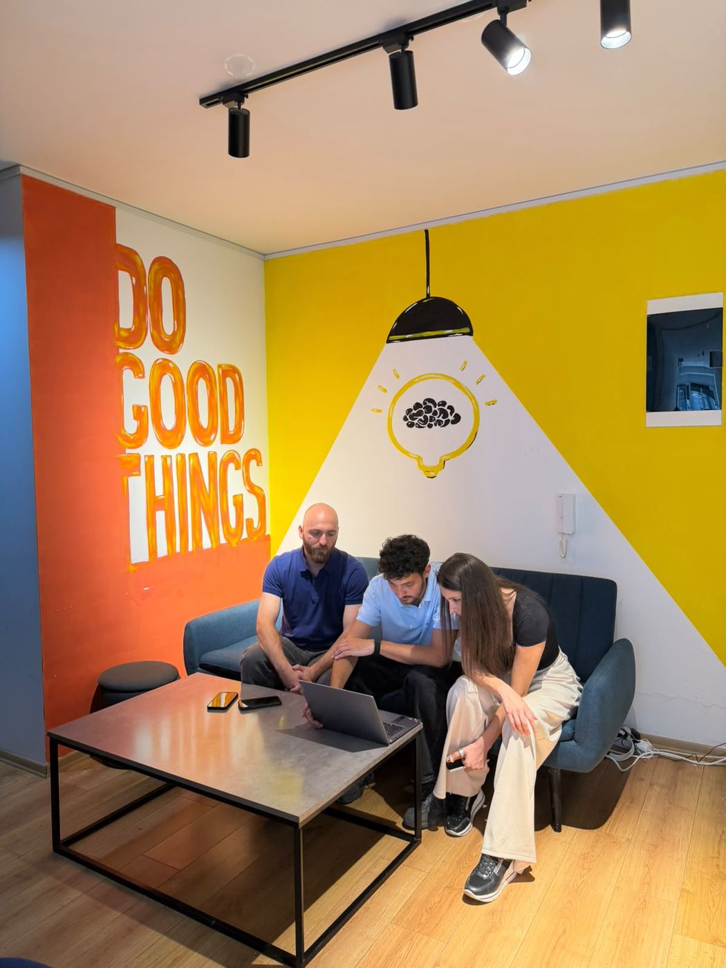 Three team members around a laptop in the office